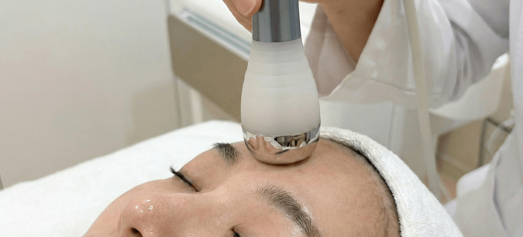 Professional skin treatment using LDM Smart ultrasound device on a patient's forehead at Edition Clinic in Thonglor, Bangkok