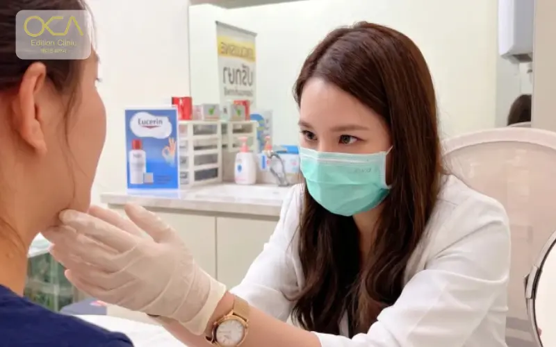 Aesthetic doctor examining a patient's jawline before botulinum toxin treatment at Edition Clinic Bangkok